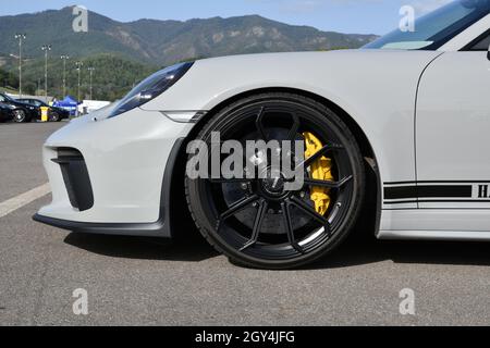 Mugello Circuit, Italy - 23 September 2021: detail of an alloy wheel rim with yellow brake caliper of a Porsche 911 in the paddock of Mugello Circuit. Stock Photo