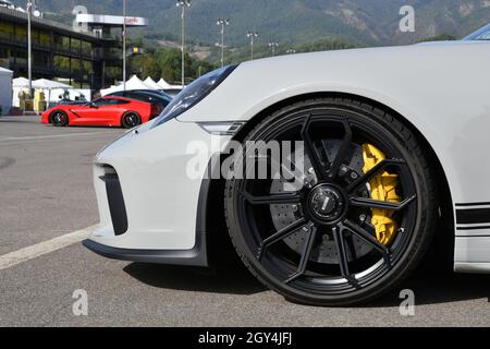 Mugello Circuit, Italy - 23 September 2021: detail of an alloy wheel rim with yellow brake caliper of a Porsche 911 in the paddock of Mugello Circuit. Stock Photo