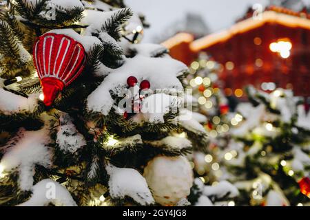 Snow Covered Christmas Tree With Toys And Blurred Bokeh Lights On Festive Background. Merry Christmas And Happy New Year Atmosphere 2022 Stock Photo - Alamy