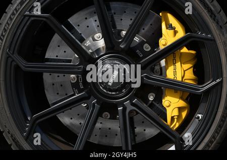 Mugello Circuit, Italy - 23 September 2021: detail of an alloy wheel rim with yellow brake caliper of a Porsche 911 in the paddock of Mugello Circuit. Stock Photo