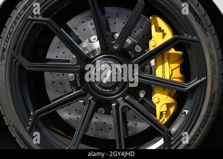 Mugello Circuit, Italy - 23 September 2021: detail of an alloy wheel rim with yellow brake caliper of a Porsche 911 in the paddock of Mugello Circuit. Stock Photo