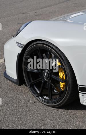 Mugello Circuit, Italy - 23 September 2021: detail of an alloy wheel rim with yellow brake caliper of a Porsche 911 in the paddock of Mugello Circuit. Stock Photo