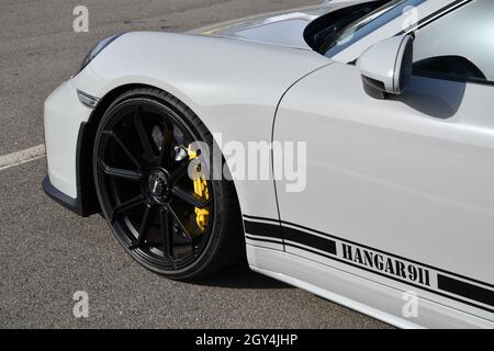 Mugello Circuit, Italy - 23 September 2021: detail of an alloy wheel rim with yellow brake caliper of a Porsche 911 in the paddock of Mugello Circuit. Stock Photo