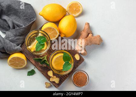 Tea with ginger and lemon on a light gray background. Top view, copy space. Stock Photo