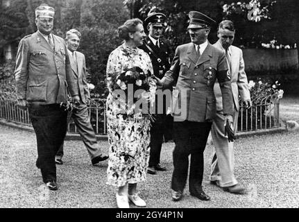 On the left are Wilhelm Brückner, Hitler's chief adjutant until that year, Winifred Wagner's son Wolfgang, the festival director Winifred Wagner, Richard Wagner's daughter-in-law, an SS man from Hitler's bodyguard (Führerbegleitkommando), Adolf Hitler and Richard Wagner's eldest son and grandson Wieland. Wolfgang later withdrew his mother's right to attend the festival when he was the director himself, after she repeatedly showed herself to be an old Nazi. Even without a year, this picture would easily date to 1940, as Hitler wore tails at the festival until that year. With the start of the Stock Photo