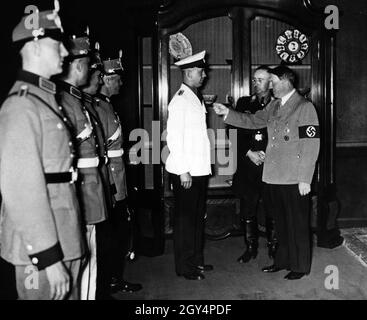 Reichsführer SS and Chief of the German Police Heinrich Himmler shows Adolf Hitler new designs of police uniforms. Members of the Ordnungspolizei like these were also involved in the massacres on the Eastern Front as part of Reserve Battalions and provided political terror at home by the Nazi regime. [automated translation] Stock Photo