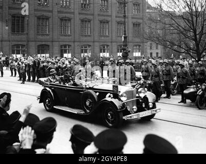 Adolf Hitler, together with Werner von Blomberg, Erich Raeder and Sepp Dietrich, is driven past a formation of the Wehrmacht with a military band by Erich Kempka in front of the Red Palace in Berlin. [automated translation] Stock Photo