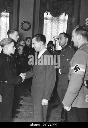 Propaganda Minister Joseph Goebbels (center) receives a number of Hitler Youth from the Rhineland who are awarded the Cross of War Merit or the Iron Cross 2nd Class for their bravery during the air raids on their city. To the right of Goebbels is Reich Youth Leader Axmann. [automated translation] Stock Photo