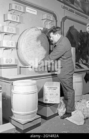 Arbeiter rollen Butter und Käse aus Lettland an den Messestand auf der Messe Lepzig, Deutschland 1940er Jahre. Workers carrying butter and cheese from Latvia to the booth at the Leipzig trade show, Germany 1940s. Stock Photo
