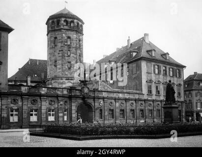 The photograph shows the statue for Maximilian II in the courtyard of honour of the Old Palace in Bayreuth in 1930. Behind it you can see the castle tower. Two children are riding their bicycles across the square. [automated translation] Stock Photo