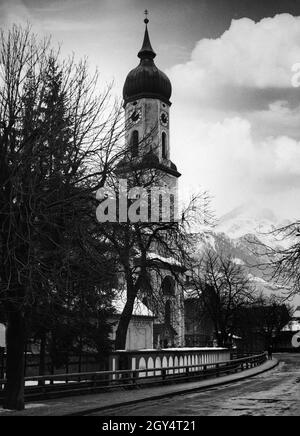 The photograph shows the parish church of St. Martin in Garmisch-Partenkirchen on February 5, 1936 as seen from Promenadestraße. The Alpspitze can be glimpsed in the background. The Winter Olympics began on 6 February. [automated translation] Stock Photo