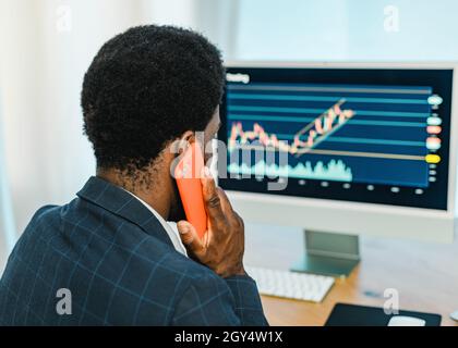 Black male trader talking on smartphone Stock Photo