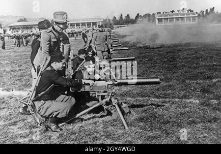 In a training camp near Rome, members of the fascist youth organization Opera Nazionale Balilla practice how to operate a machine gun. Two youths at a time operate one of the rifles under the supervision of an officer of the Italian army. The Duke of Spoleto, Prince Aimone of Aosta, visited the exercise. [automated translation] Stock Photo