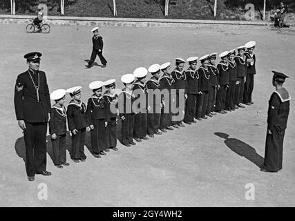 'A group of young Italian boys in sailor suits lined up in the courtyard of the Balilla House of the Marinaretti in Rome in 1933. The children are members of the Marinaretti, the ''little sailors'' within the fascist Opera Nazionale Balilla. They are under the command of officers of the Italian Navy and are drilled at an early age. The Marinaretti house was located on the right bank of the Tiber River in Rome, in the street Lungotevere Flaminio. [automated translation]' Stock Photo