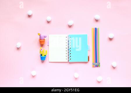 Items for drawing on a pink background. Layout from the sketching kit. Notepad, eraser and pencils on a pink background. View from above Stock Photo