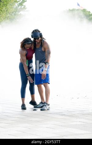 A muscular attractive couple take a selfie at the Fountain of the Fairs in Flushing Meadows Corona Park in Queens, New York City. Stock Photo