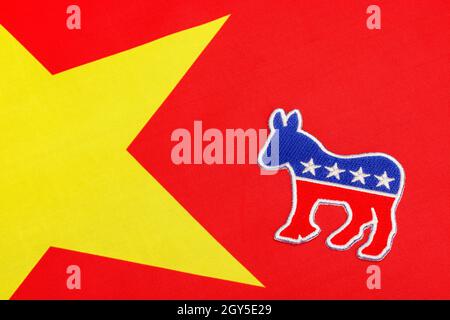 Dems / Democrat donkey logo set against a polyester red Chinese flag. For Democrat China ties, Hunter Biden China connections, Joe Biden China ties. Stock Photo