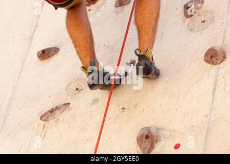 Young man climbing in an urban climbing wall, detail of the feet, Stock Photo