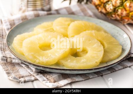 Canned sliced pineapple fruit on plate. Stock Photo