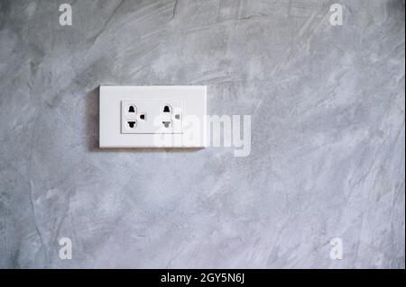 outlet Power saving Hand inserting electrical plug into outlet Stock Photo