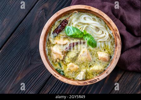 Bowl of green curry noodles decorated wih fresh basil Stock Photo