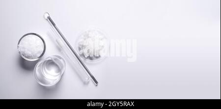 Crystal clear liquid in beaker, Microcrystalline wax in glass container, Flake salt in Chemical Watch Glass placed next to the Stirring Rod and Test t Stock Photo