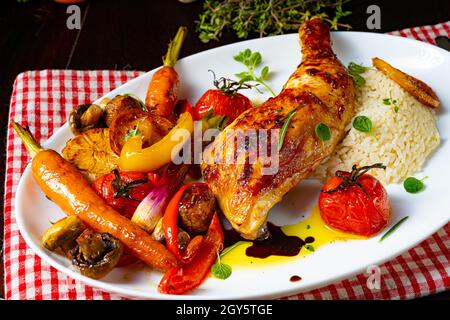 Rustic fried chicken legs with assorted vegetables and rice Stock Photo