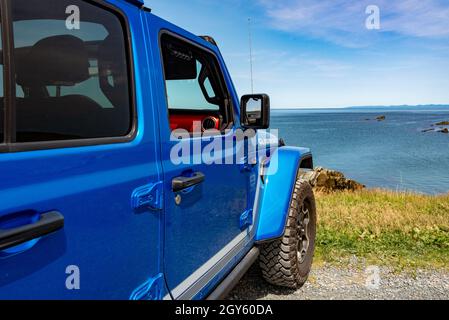 A Vibrant Blue Jeep Gladiator Rubicon Truck 4x4 Off Road And Parked On The Side Of A Hill With The Blue Ocean Blue Sky And Clouds In The Background Stock Photo Alamy
