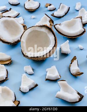 Broken coconut shells on a blue background Stock Photo