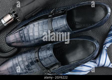 Classic blue men's shoes, tie, umbrella on the black leather, can be used as background Stock Photo