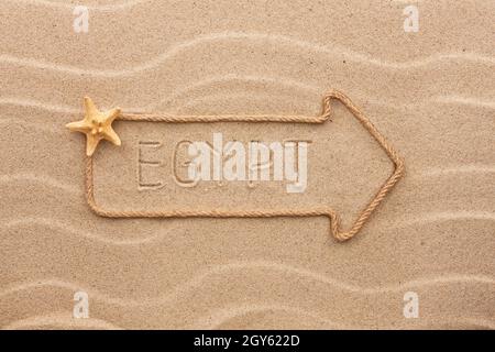 Arrow made of rope and sea shells with the word Egypt  on the sand, as background Stock Photo