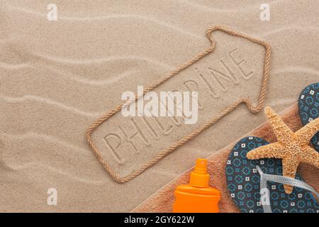 Philippines pointer and beach accessories lying on the sand, as background Stock Photo