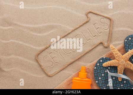 Seychelles pointer and beach accessories lying on the sand, as background Stock Photo