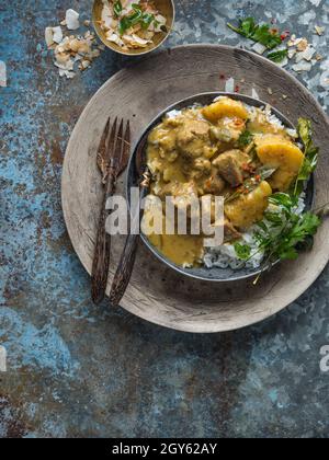 Pork Massaman Curry served with rice in a bowl with a knife and fork Stock Photo