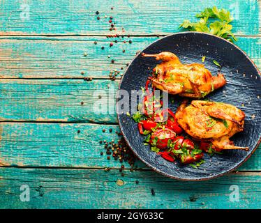 Roasted whole quail and spring vegetable salad.Appetizing baked quail meat.Space for text Stock Photo