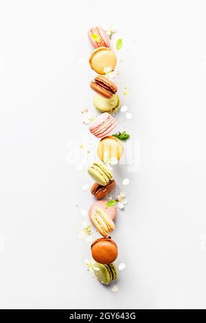 Vintage pastel colored French macaroons or macarons in motion falling on light grey background. Macaron Sweets Stock Photo