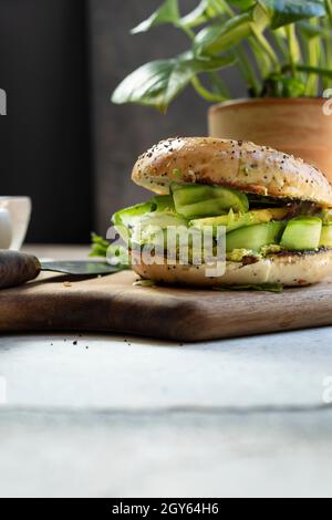 Cucumber Bagel sandwich on a wooden chopping board Stock Photo