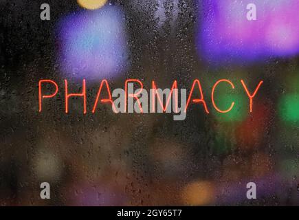 Neon Pharmacy Sign in Wet Window Stock Photo