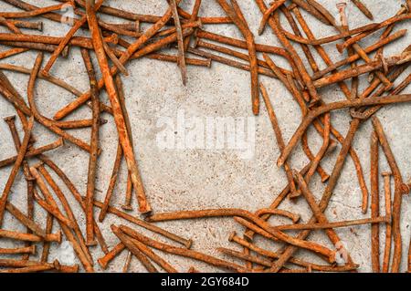 Rusty used nails on a cement metal background Stock Photo