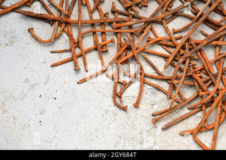 Rusty used nails on a cement metal background Stock Photo