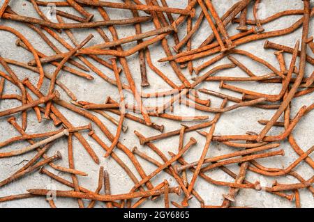 Rusty used nails on a cement metal background Stock Photo
