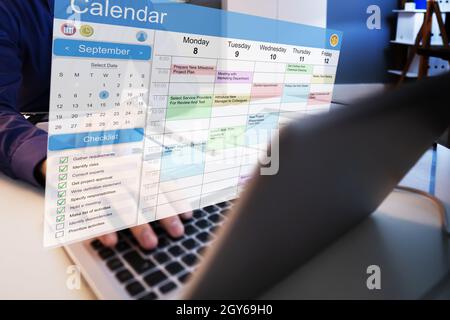 Executive Looking At Calendar On Computer. Arranging Weekly Schedule ...