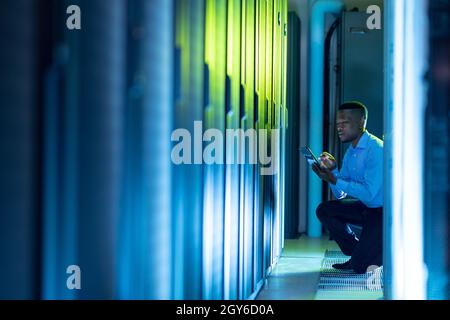 African american male computer technician using tablet working in server room Stock Photo