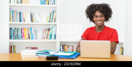Laughing afro american male student learning and working at computer with copy space Stock Photo