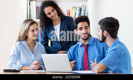 Talking international male and female business trainees at office of start up company Stock Photo