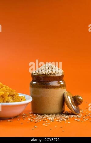 Sesame Seeds in clay pot with Jaggery in bowl Stock Photo