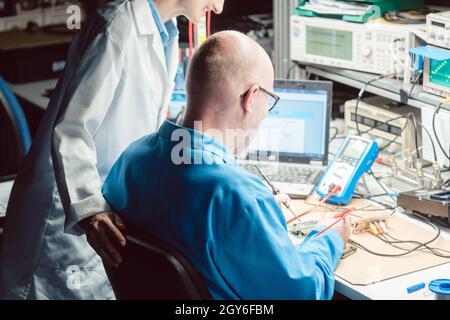 Team of development engineers designing new electronic product in the lab Stock Photo