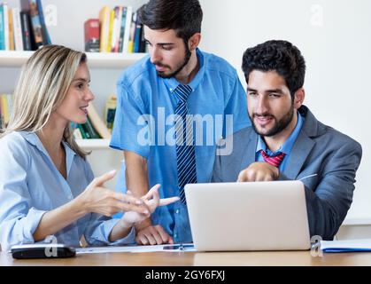 Multi ethnic team of male and female business trainees in discussion at office of start up company Stock Photo