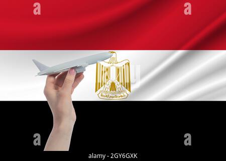 Airplane in hand with national flag of Egypt Travel to Egypt. Stock Photo