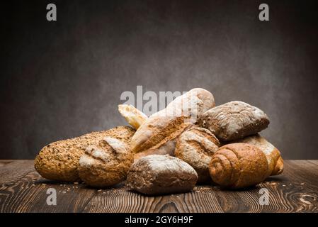 assortment of baked bread on wooden table Stock Photo